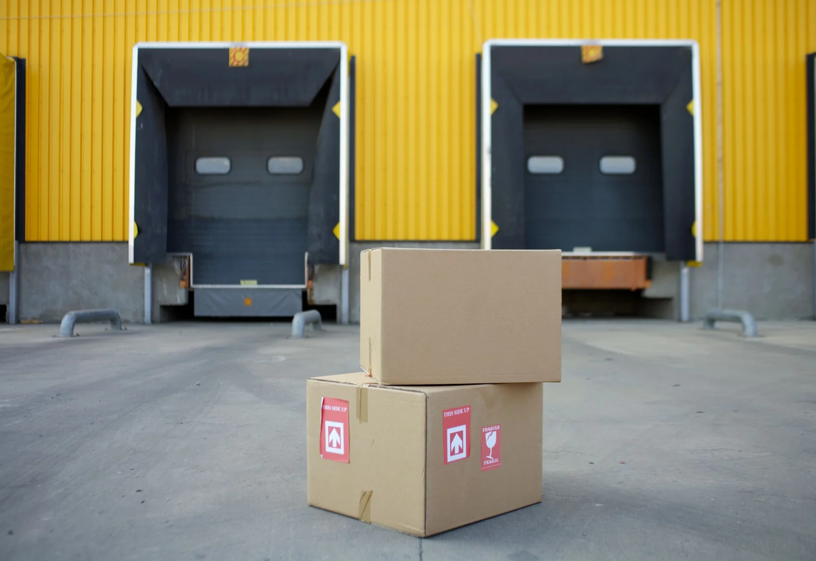 Sealed shipping cartons staged at a warehouse loading dock for packaging delivery